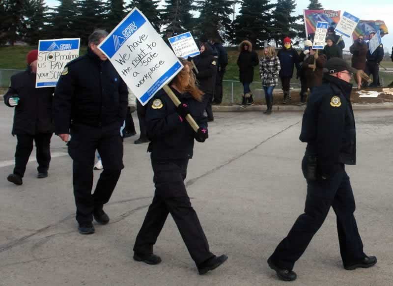 OPSEU members attend rally for corrections & hold up signs about having the right to a safe workplace