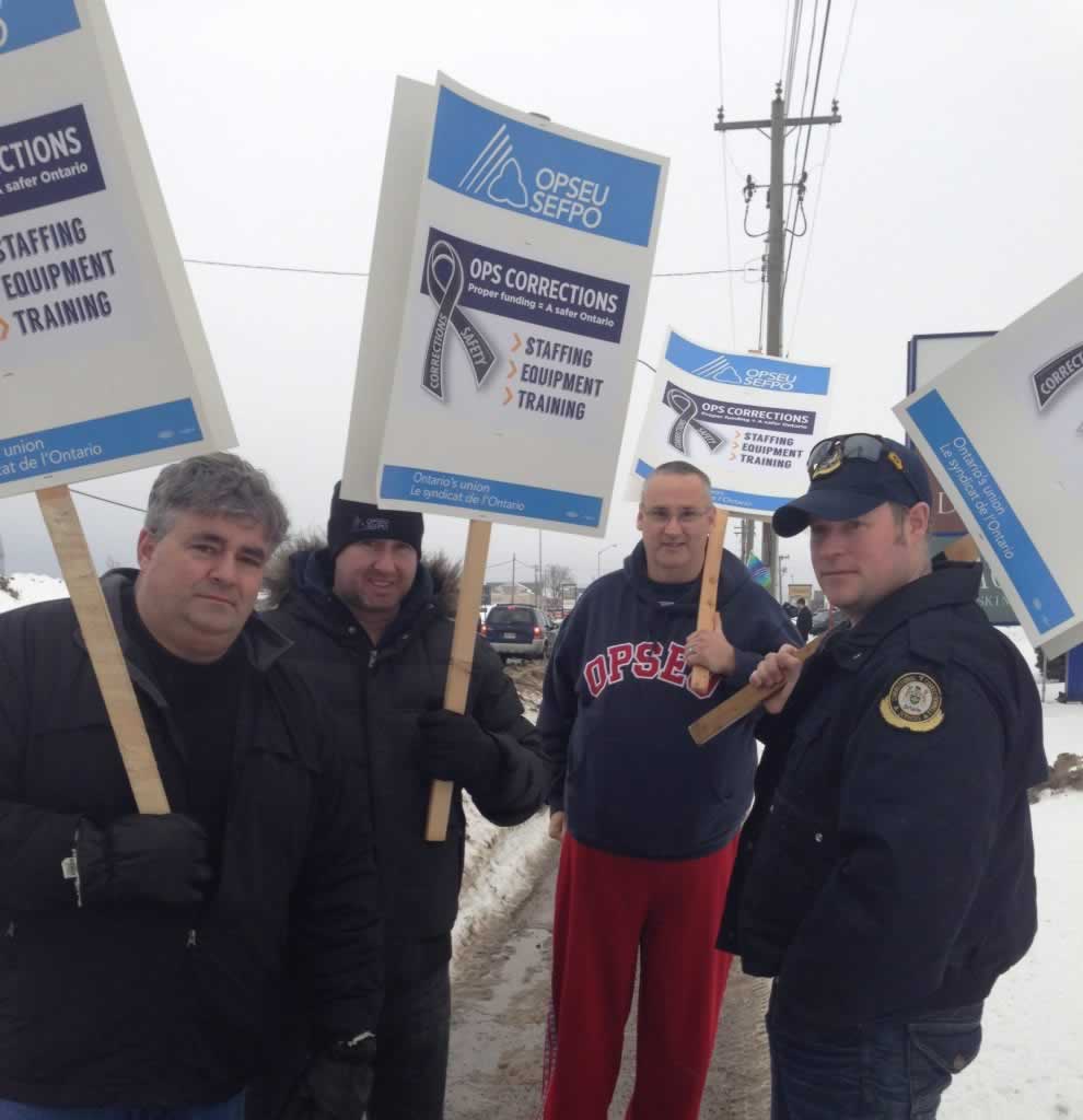 OPSEU members hold up signs as they attend rally for corrections in Sault Ste Marie