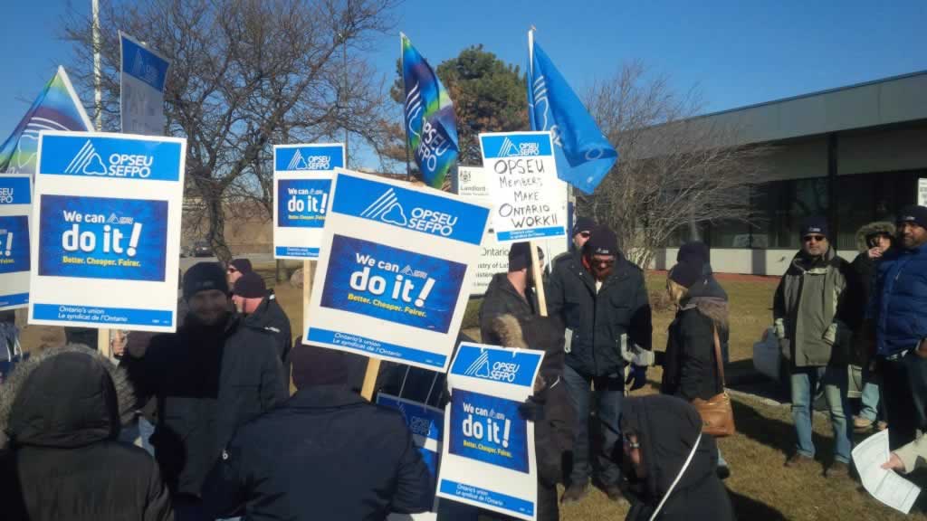 OPSEU members hold up signs as they attend rally in Midland Ave