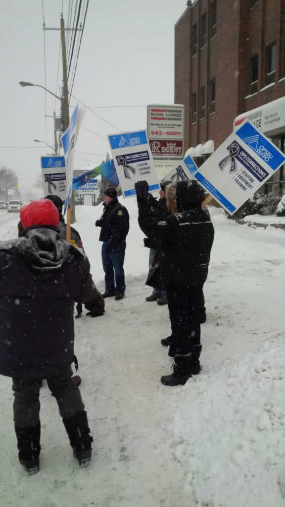 OPSEU members hold up signs as they attend rally in Sault Ste Marie