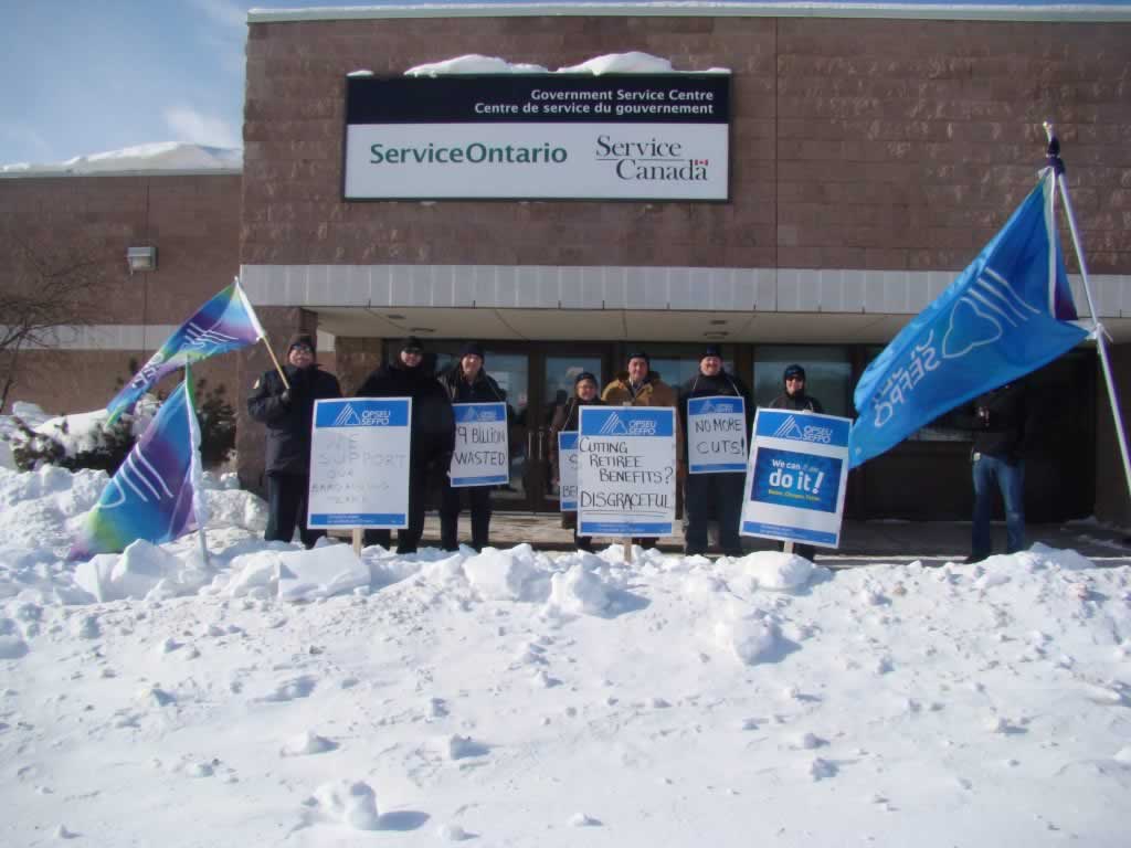 OPSEU members striking in New Liskeard outside of service ontario, holding signs