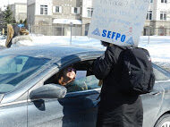 Rally in Ottawa. Member holding picket sign while talking to someone in vehicle