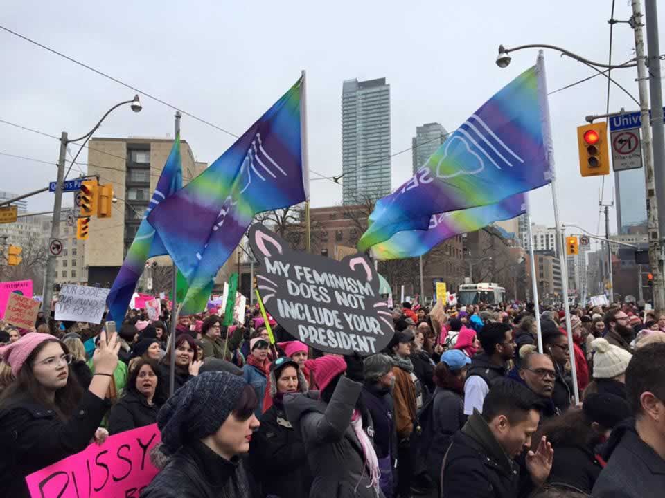 OPSEU members holding OPSEU flags during crowded Women's March in Toronto.