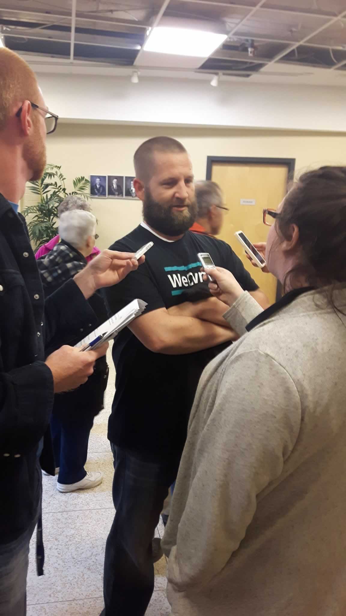 OPSEU member wearing We Own It shirt talks to reporters about Save Grey Gables campaign