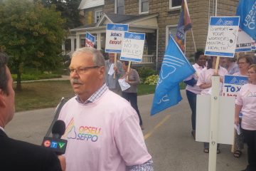 OPSEU President Warren (Smokey) Thomas speaks to reporters during a rally in Elgin
