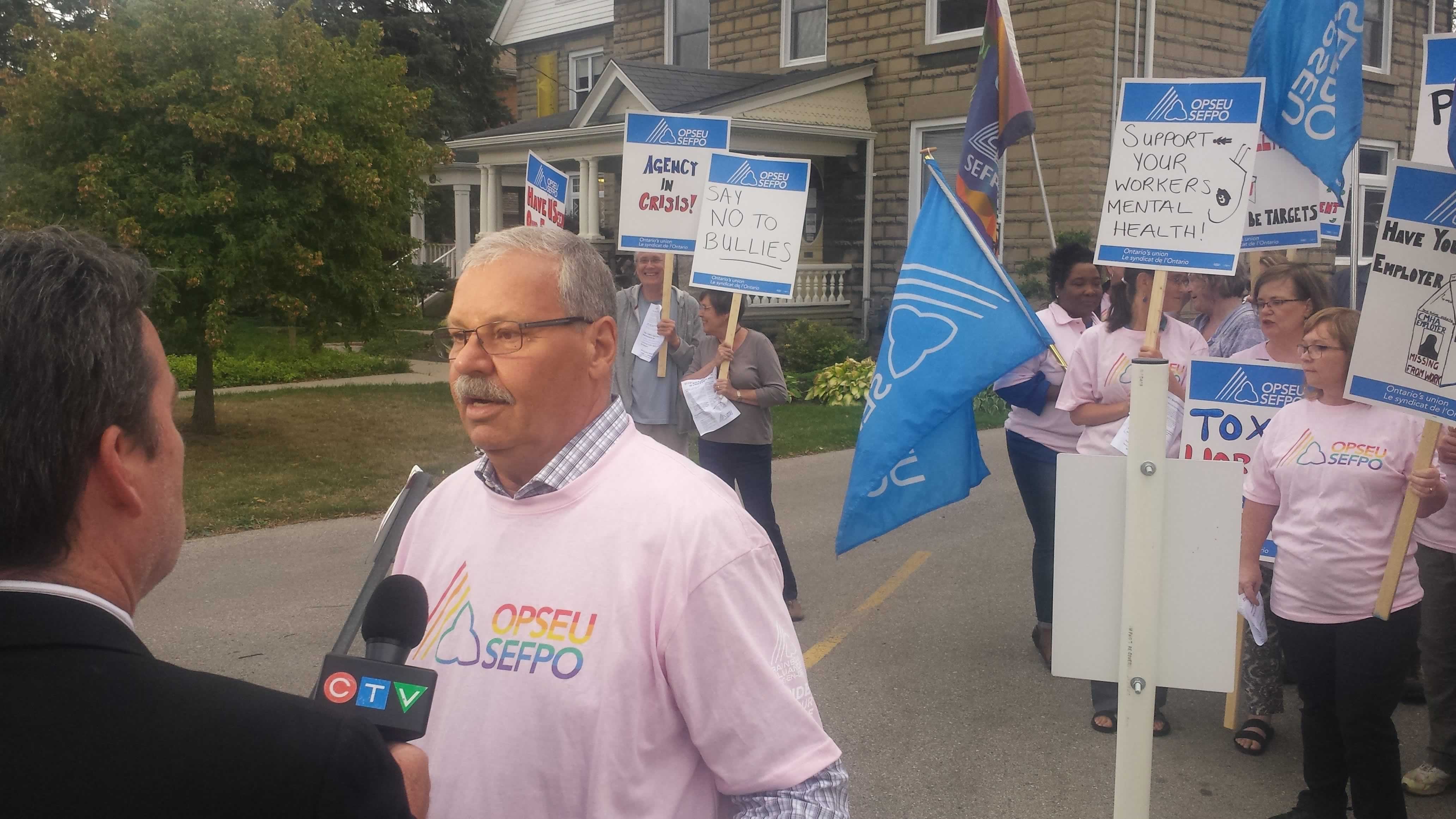 OPSEU President Warren (Smokey) Thomas speaks to reporters during a rally in Elgin