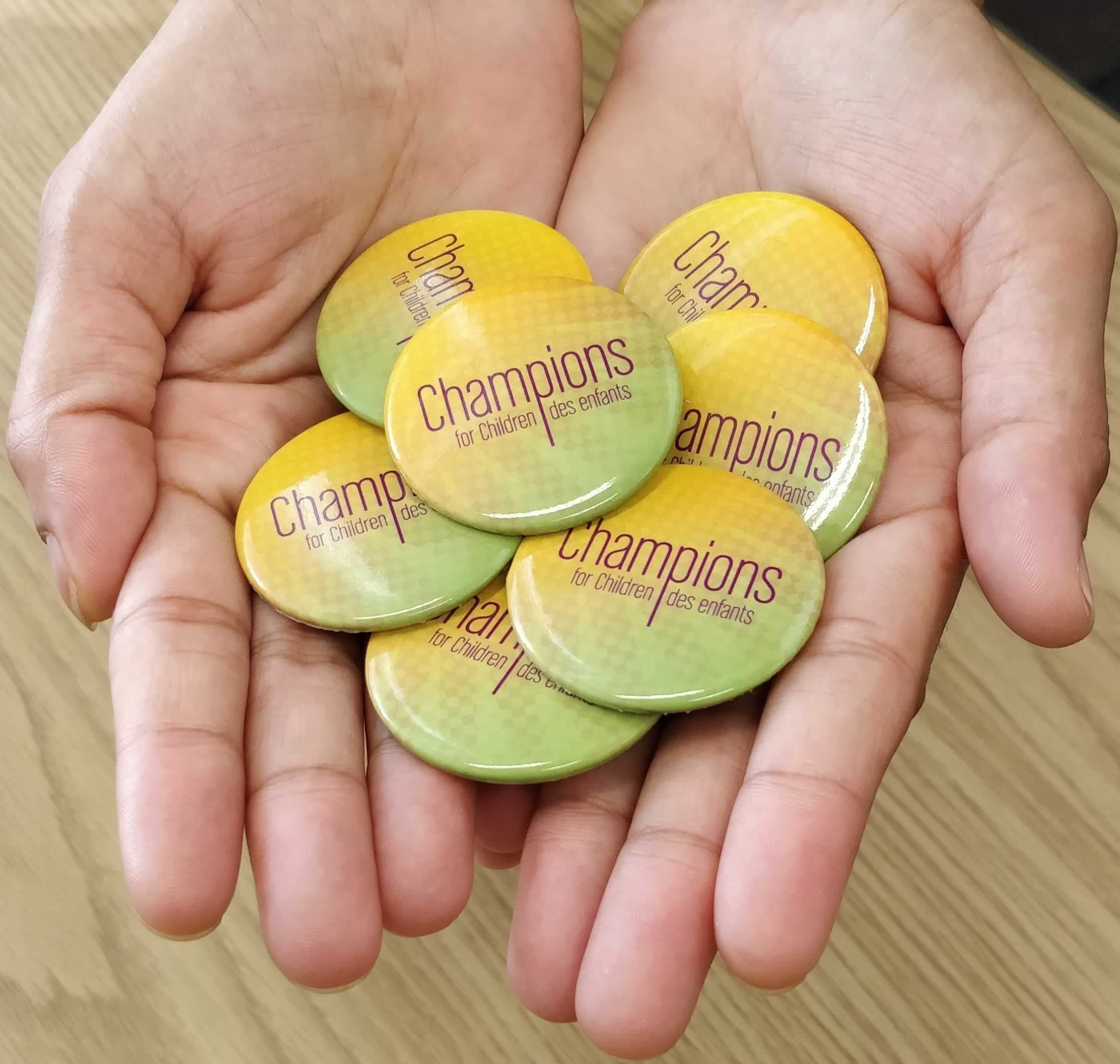 Handful of buttons that say Champions for Children / Champions des enfants