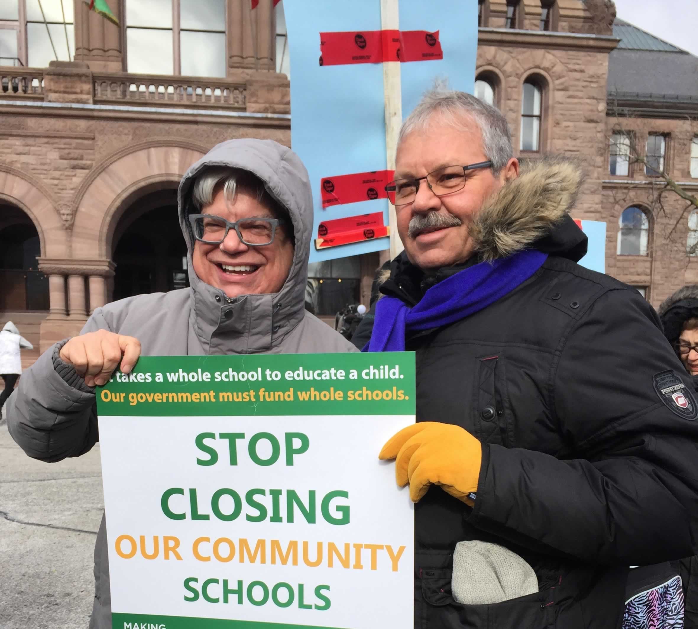 OPSEU President Warren (Smokey) Thomas and CUPE Ontario President Fred Hahn hold a sign that says "Stop closing our community schools"