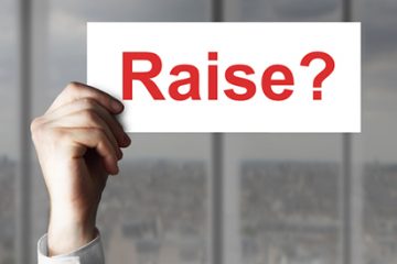 Hand holding sign with "Raise?" on it