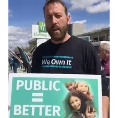 OPSEU member holds "Public = Better" sign during We Own It rally in Sudbury