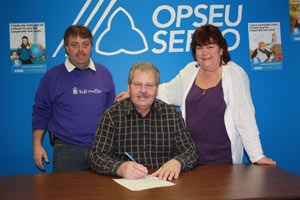 OPSEU President Warren (Smokey) Thomas signs the "Take a Stand" pledge with two other OPSEU members.