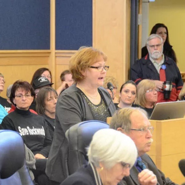 Woman speaks at a microphone during crowded Grey County Council meeting