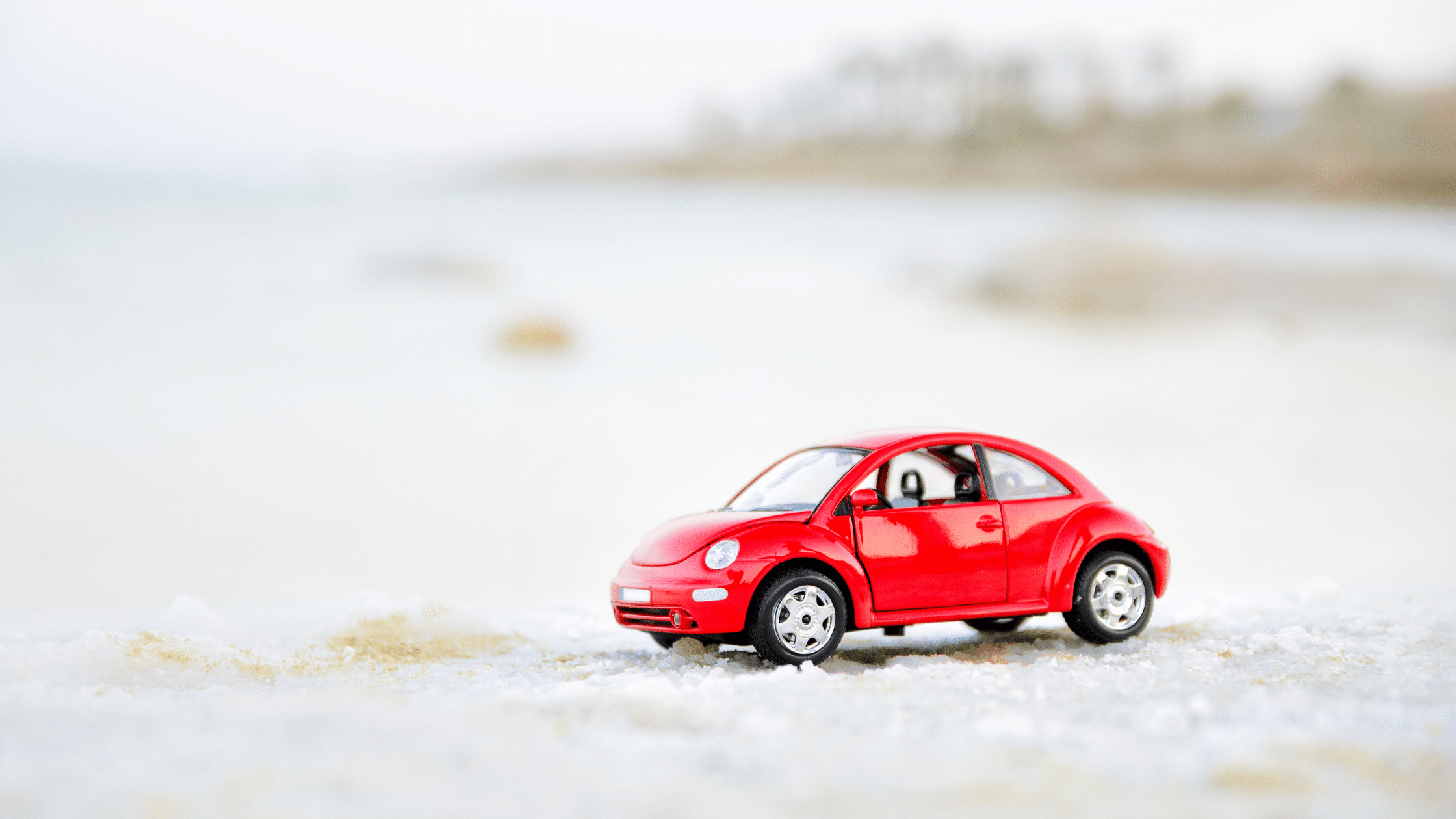 Red toy car driving in the snow