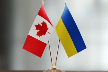 Crossed table flags of Canada and Ukraine on a desk