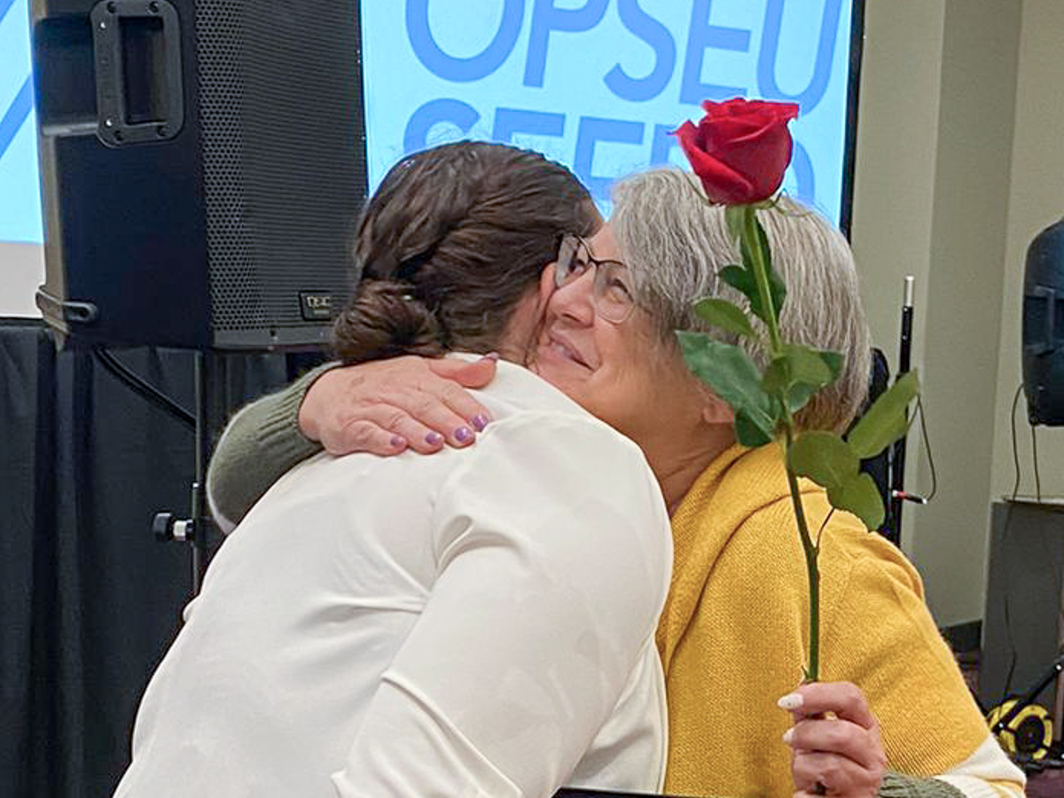 Region 1 member Taylor Phillips (left) receives a 2023 Regional Recognition Award, and a hug,from the Provincial Women's Committee