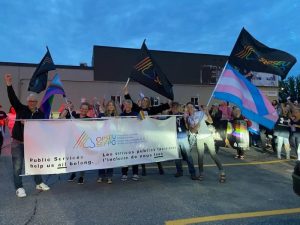 Group of marchers waving a Trans rights flag and holding an OPSEU banner 
