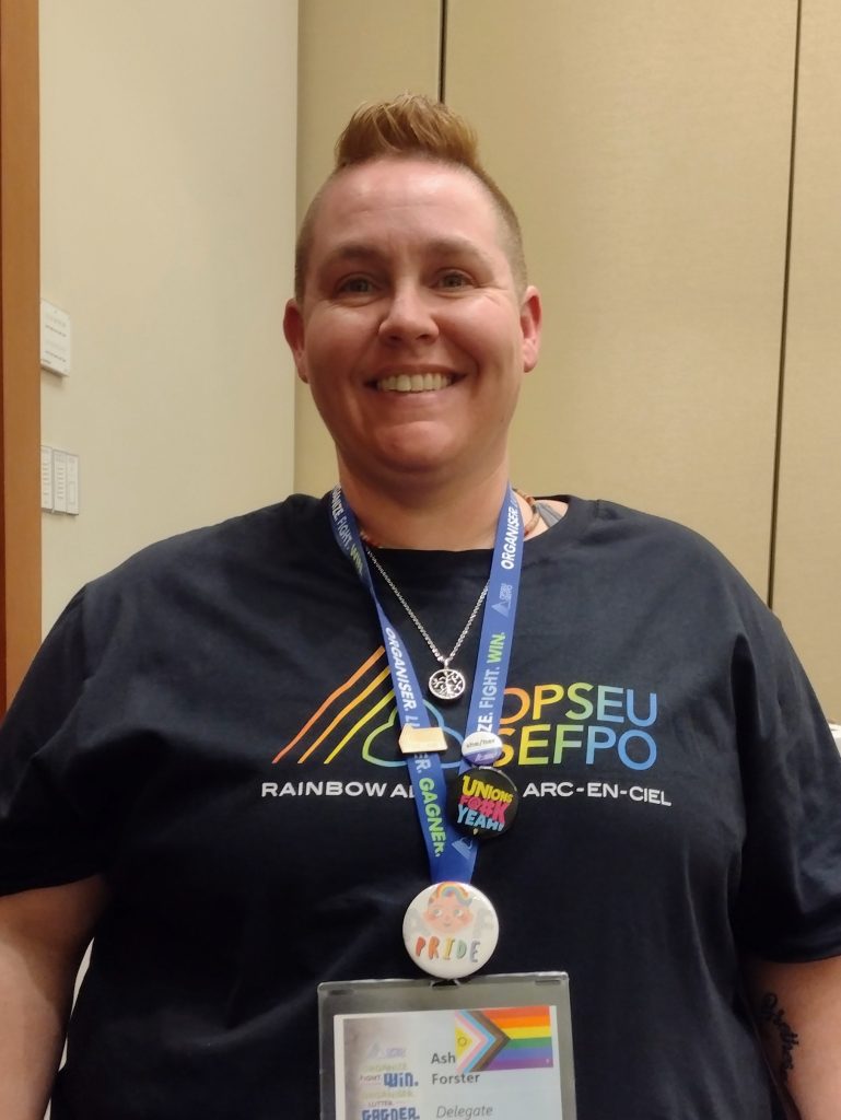 Member wearing Rainbow Alliance arc-en-ciel t-shirt with Convention credentials and button